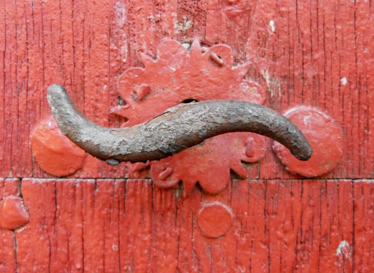 Red painted wooden door with oxidized iron handle